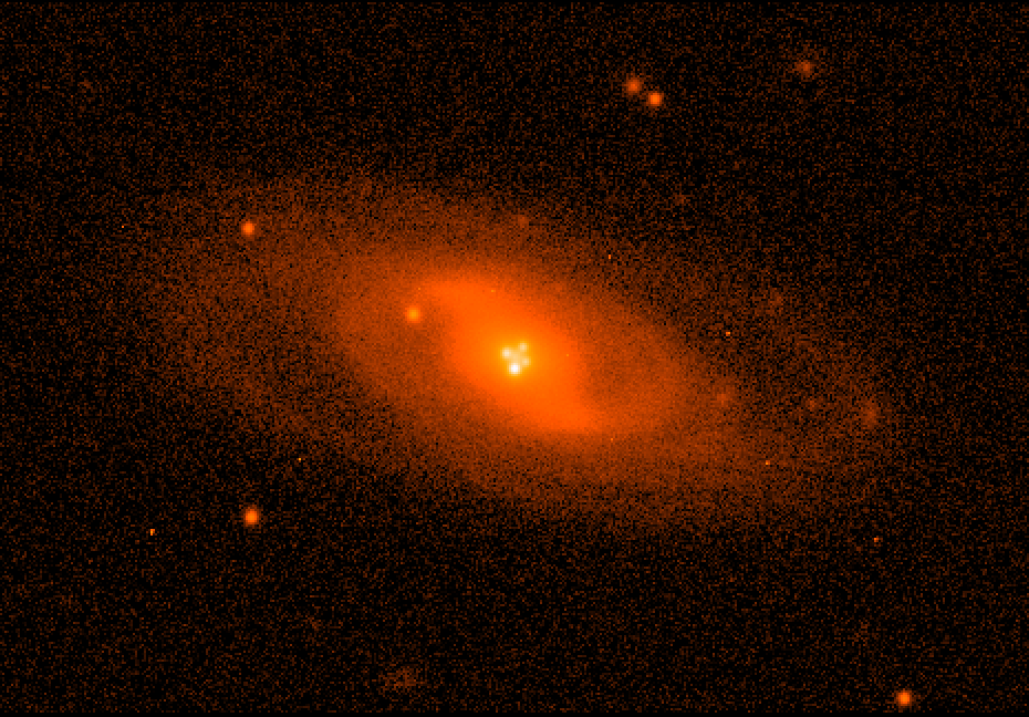 Imagen del sistema lente Q2237+0305 obtenida con el Nordic Optic Telescope en condiciones atmosféricas excelentes. Muestra la imagen de la galaxia espiral que hace de lente gravitatoria. Cerca del núcleo pueden verse las cuatro imágenes del cuásar producidas por el efecto. Imagen: Mediavilla et al. Fuente: UGR.